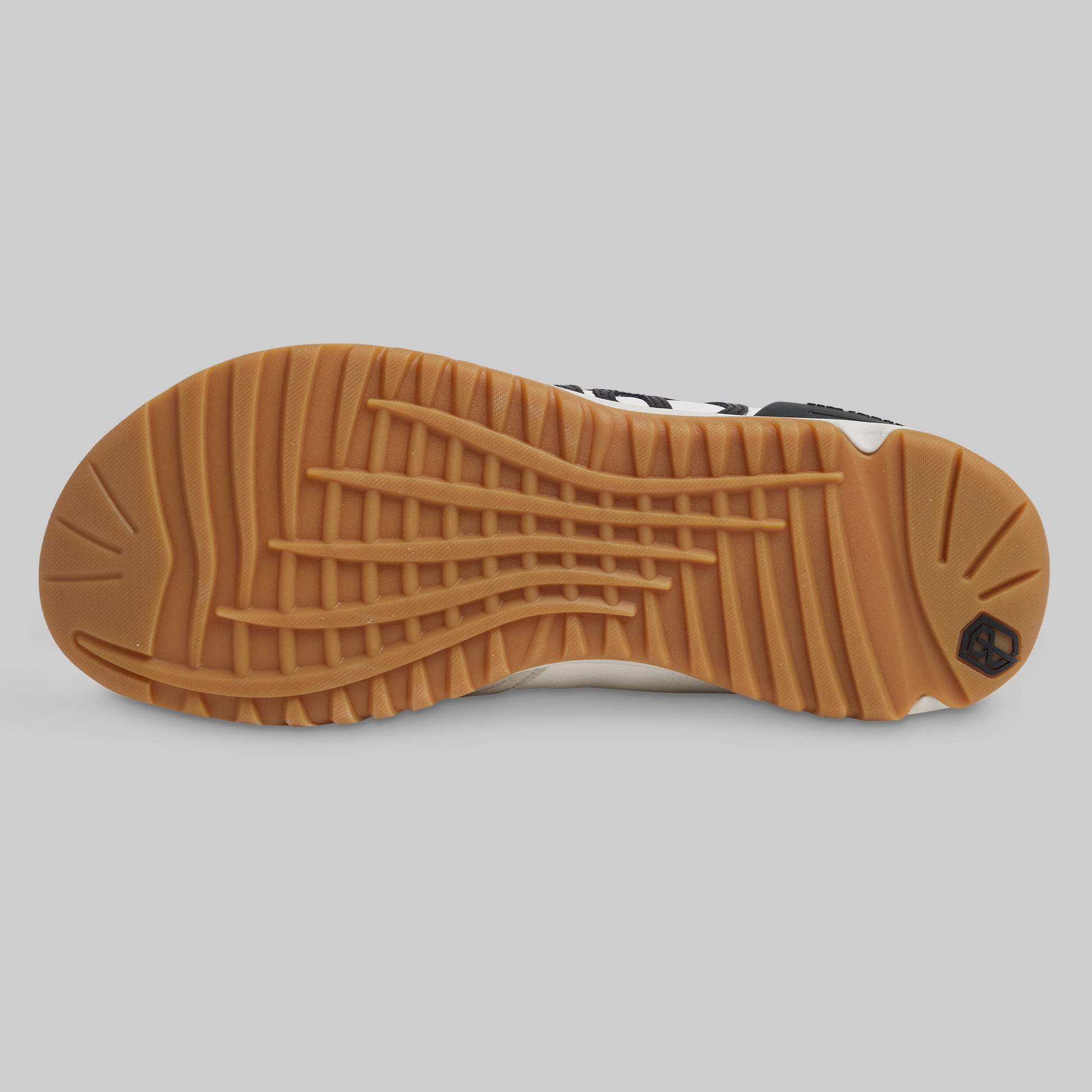 Close-up of a shoe sole with brown tread pattern on a gray background
