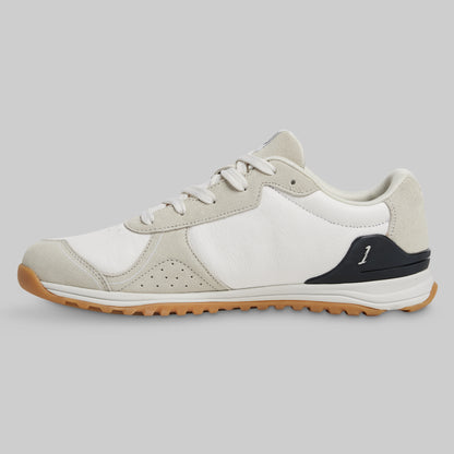 White and beige sneaker with brown sole on a gray background