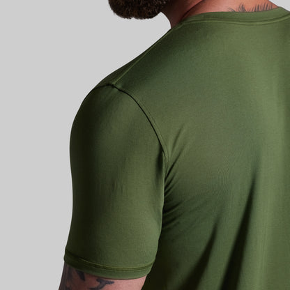 Person wearing a green t-shirt on a gray background