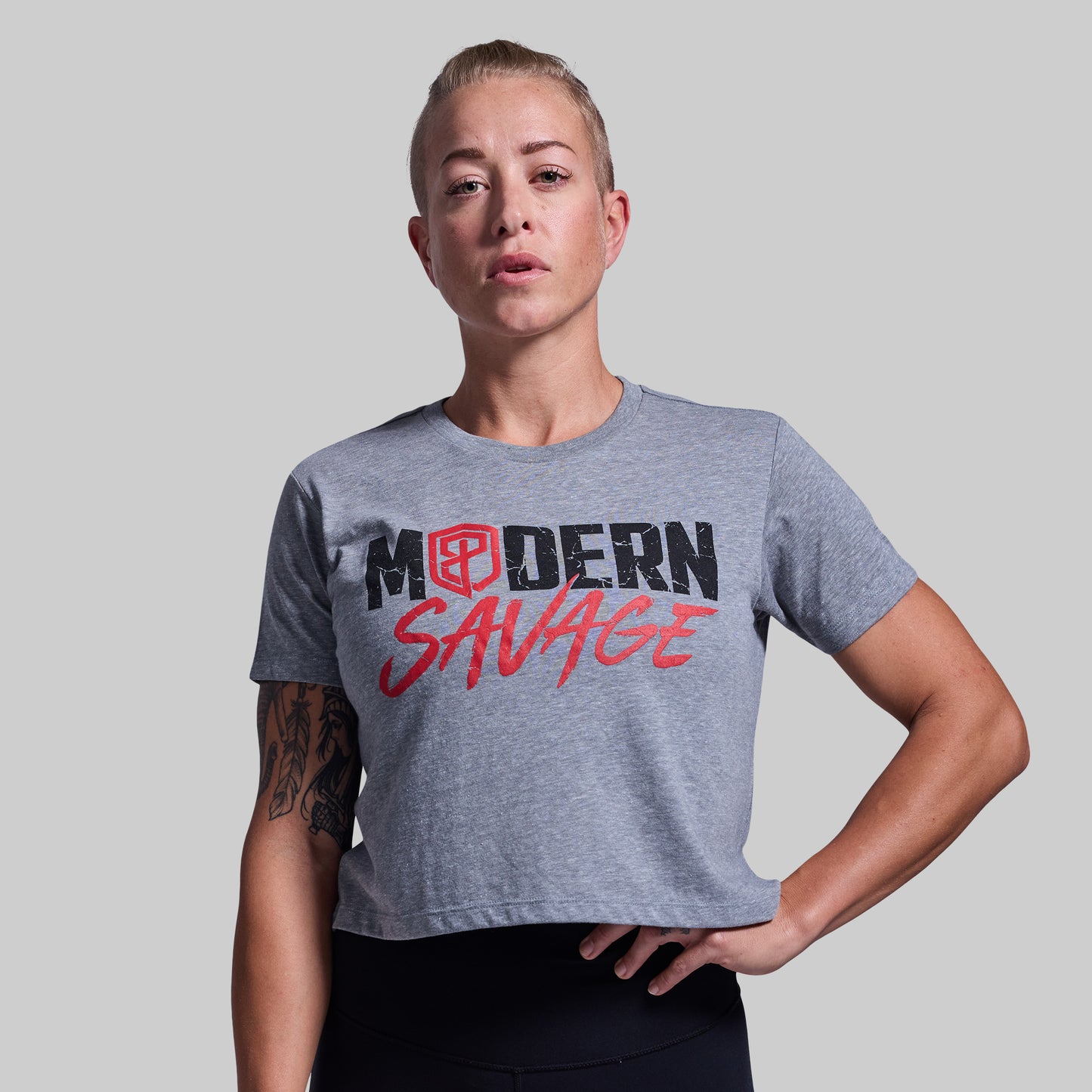 Person wearing a gray t-shirt with 'Modern Savage' text on a plain background