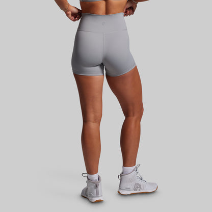 Person wearing gray athletic shorts on a plain background