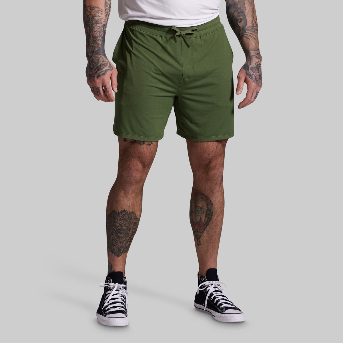Person wearing green shorts on a gray background