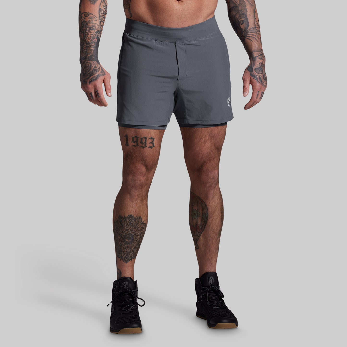 Person wearing gray athletic shorts on a plain background