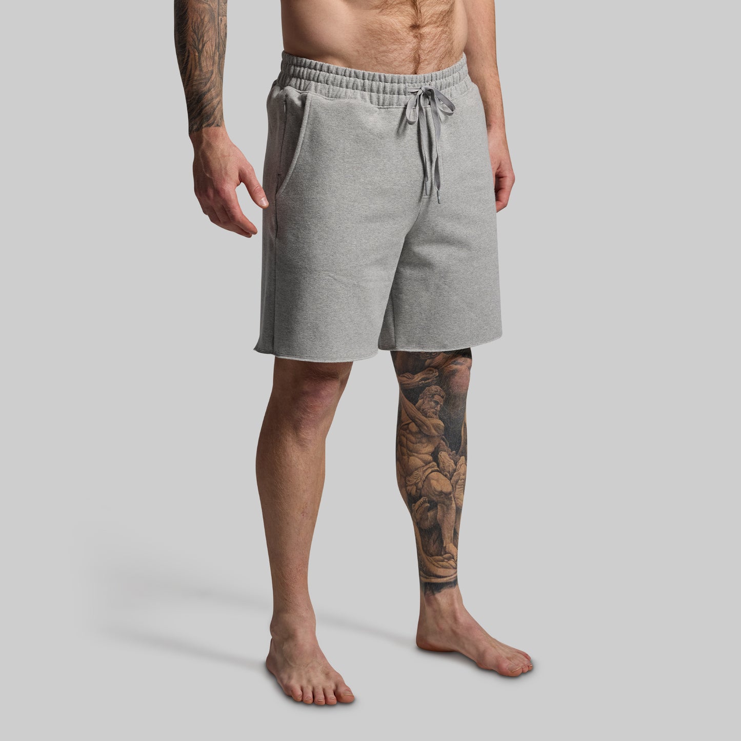 Person wearing gray shorts on a plain background