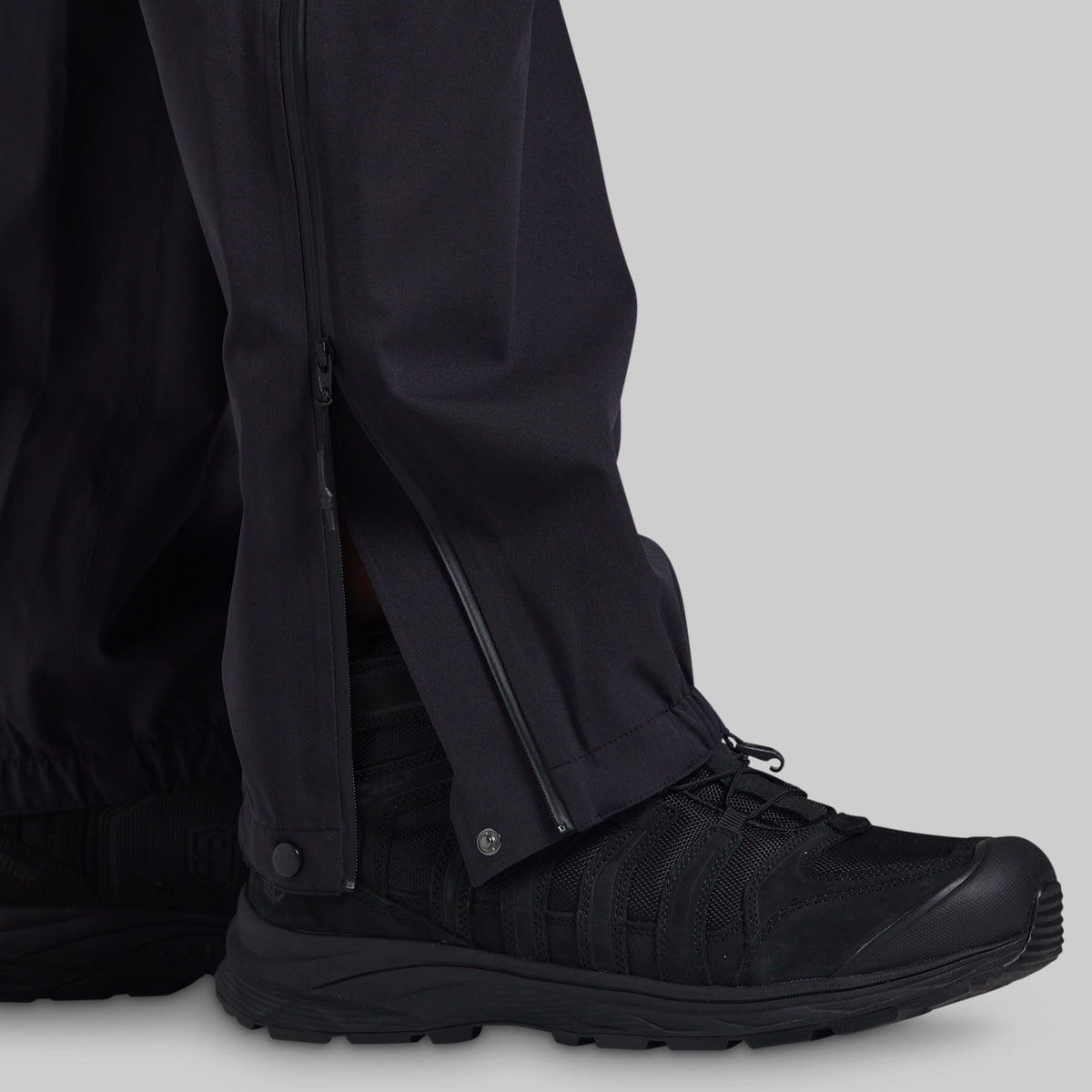 Full-length side zipper open over a boot on black Mission FLEX Rain Pant 2.0