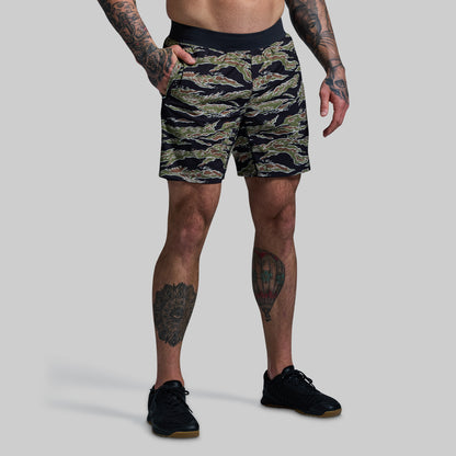 Person wearing camouflage shorts on a plain background