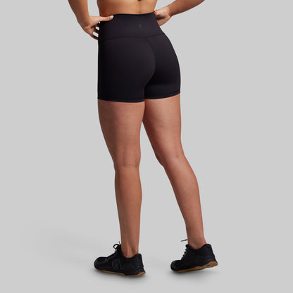Person wearing black athletic shorts on a gray background