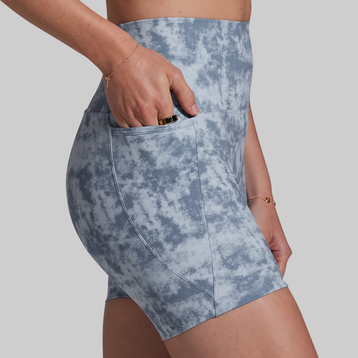 Blue tie-dye shorts worn by a person on a plain background