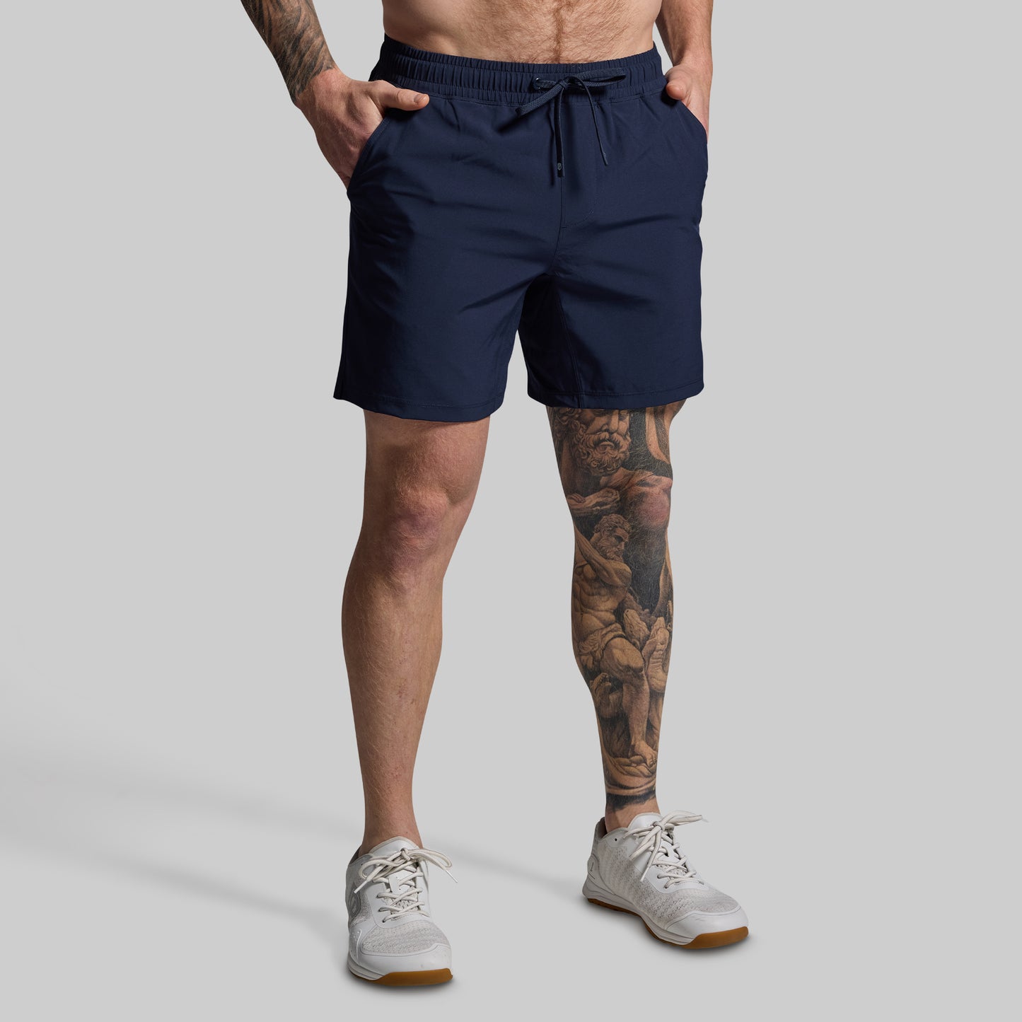 Person wearing navy shorts on a gray background