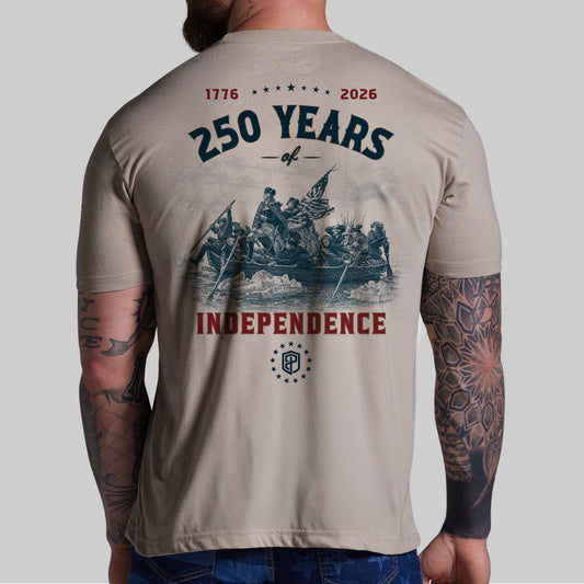 Beige t-shirt with '250 Years of Independence' design on the back, worn by a person with tattoos.