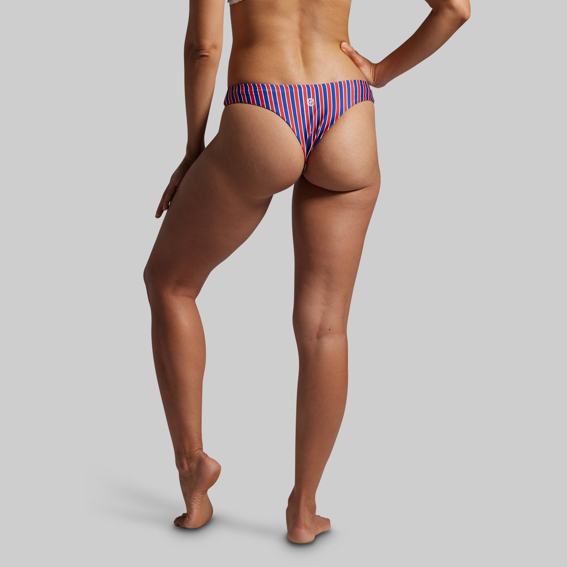 Person wearing a striped bikini bottom on a plain background