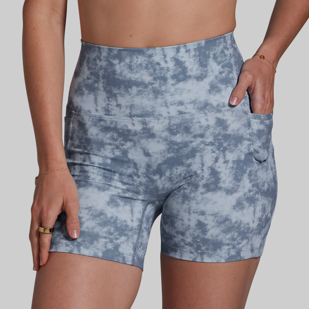 Blue tie-dye shorts worn by a person on a plain background