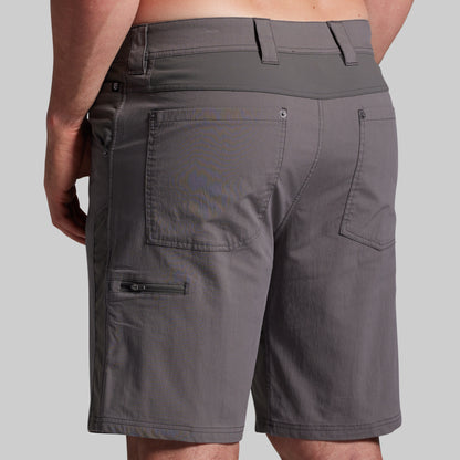 Gray shorts with multiple pockets and zippers on a gray background