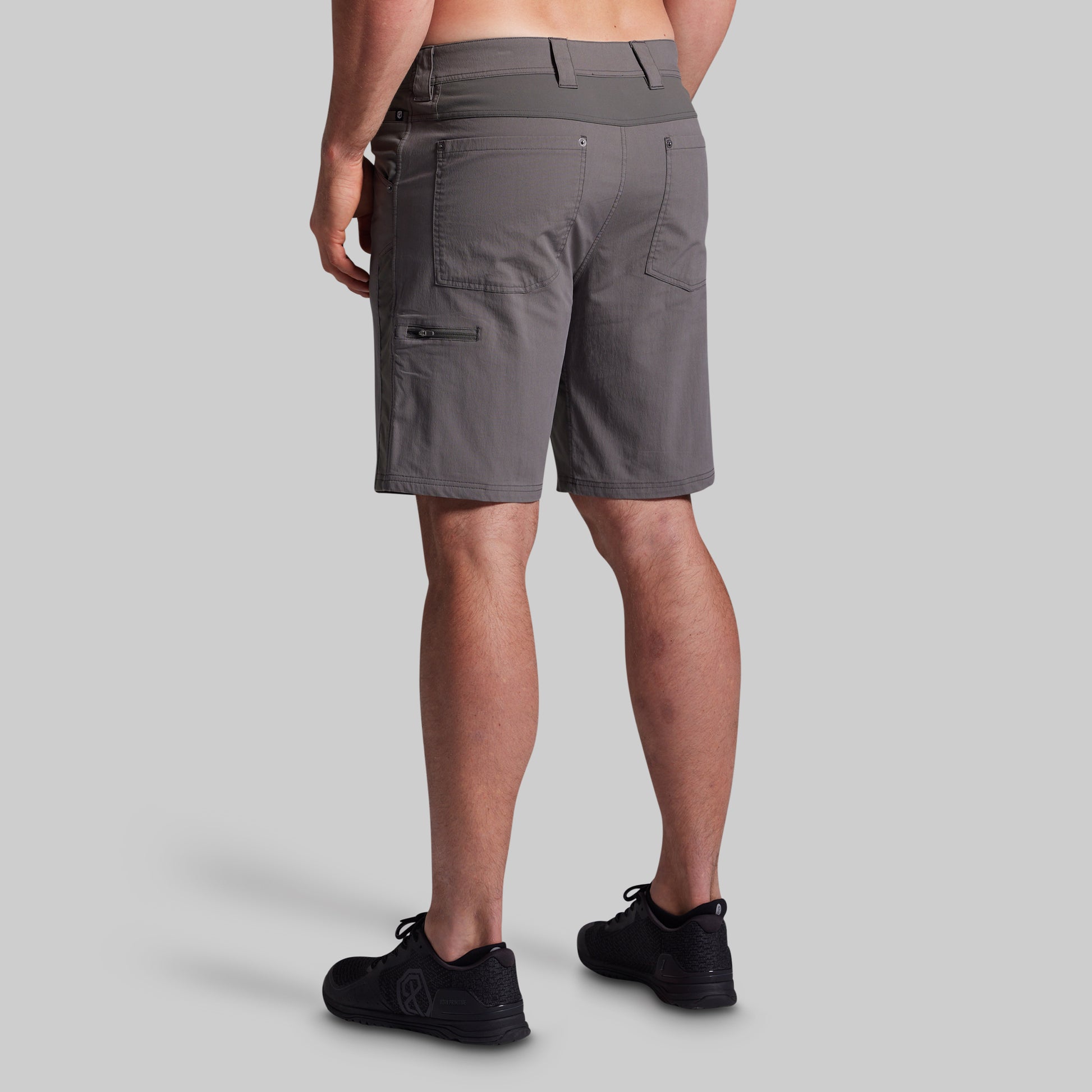 Person wearing gray shorts on a light gray background