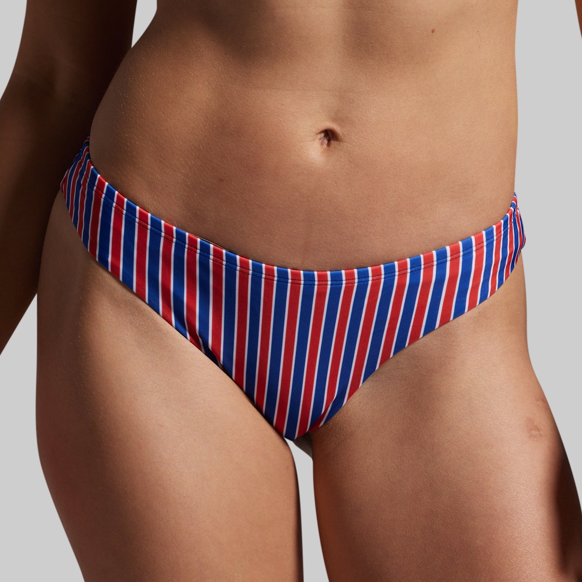 Red, white, and blue striped bikini bottom on a neutral background