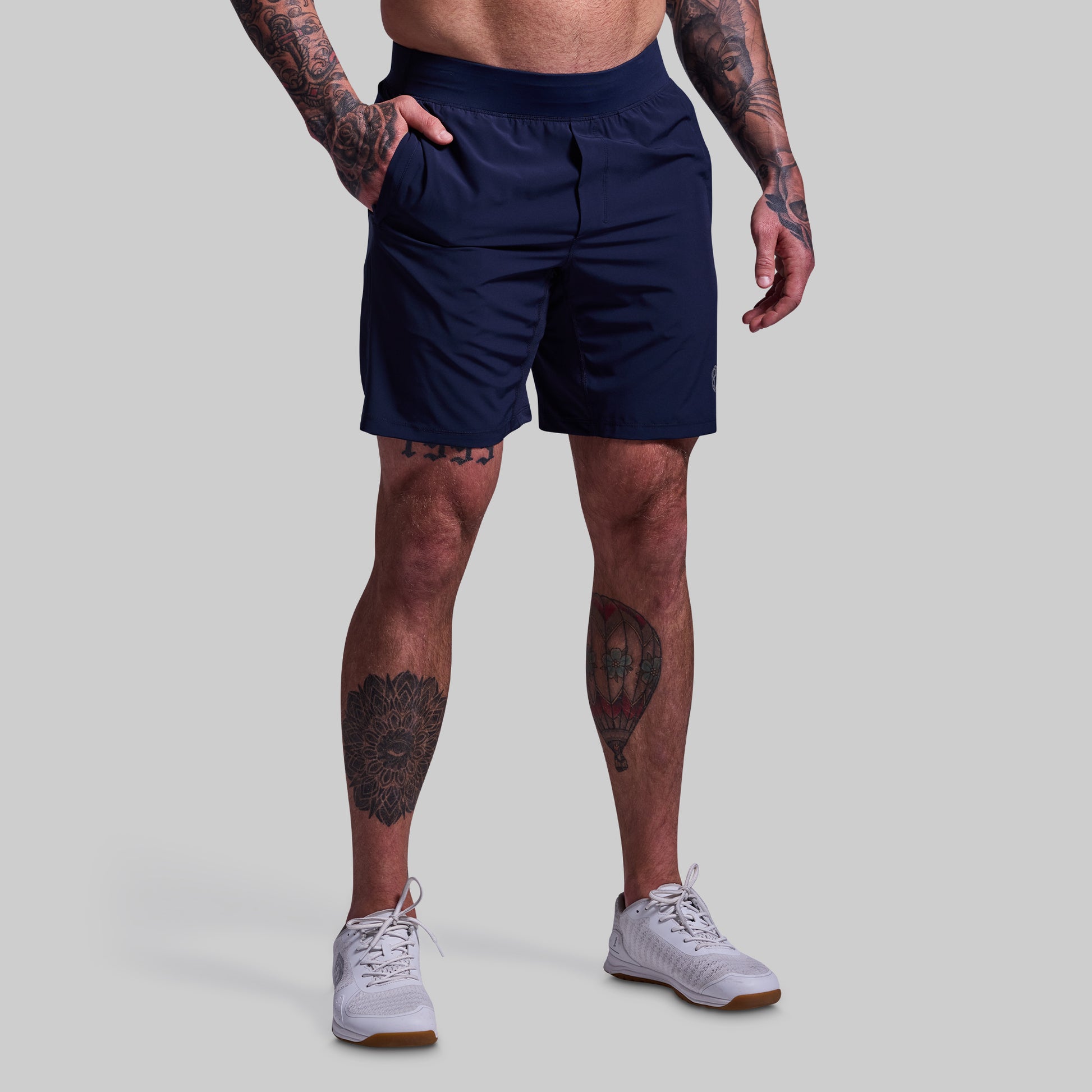 Person wearing navy shorts on a plain background