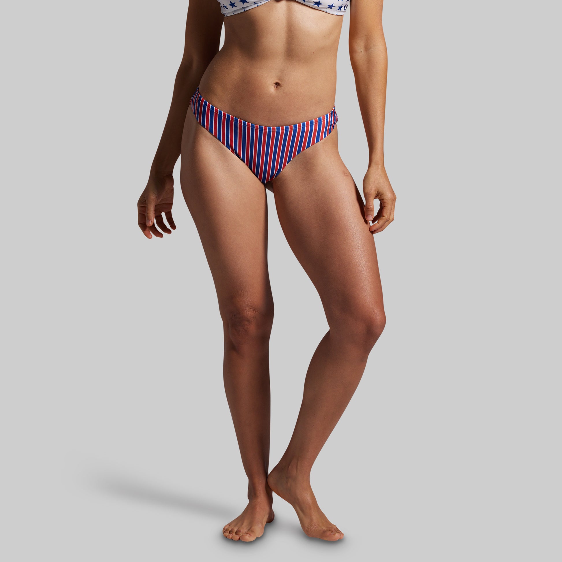 Person wearing a red and blue striped bikini bottom on a gray background