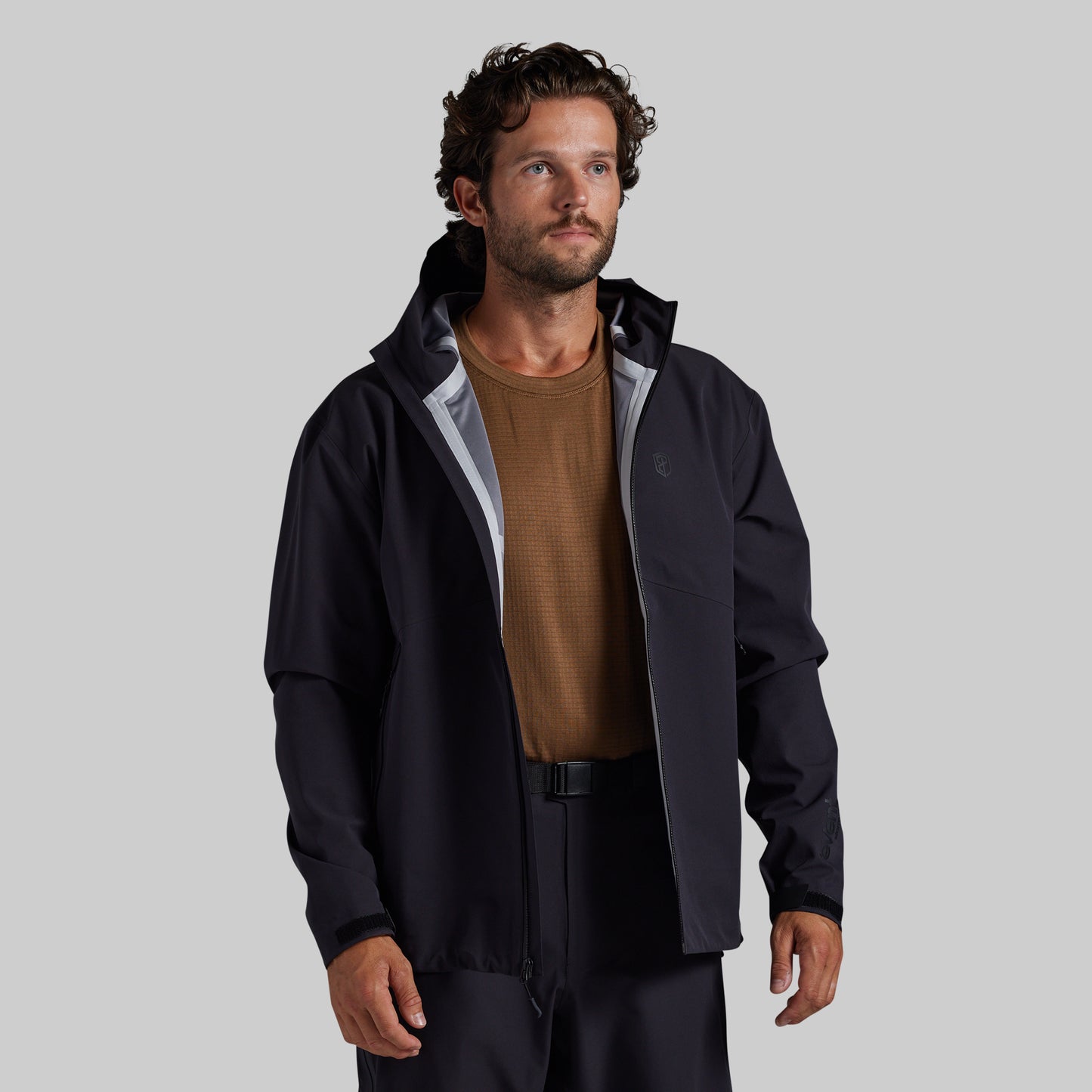 Man wearing the black Mission FLEX Rain Jacket 2.0 open over a base layer