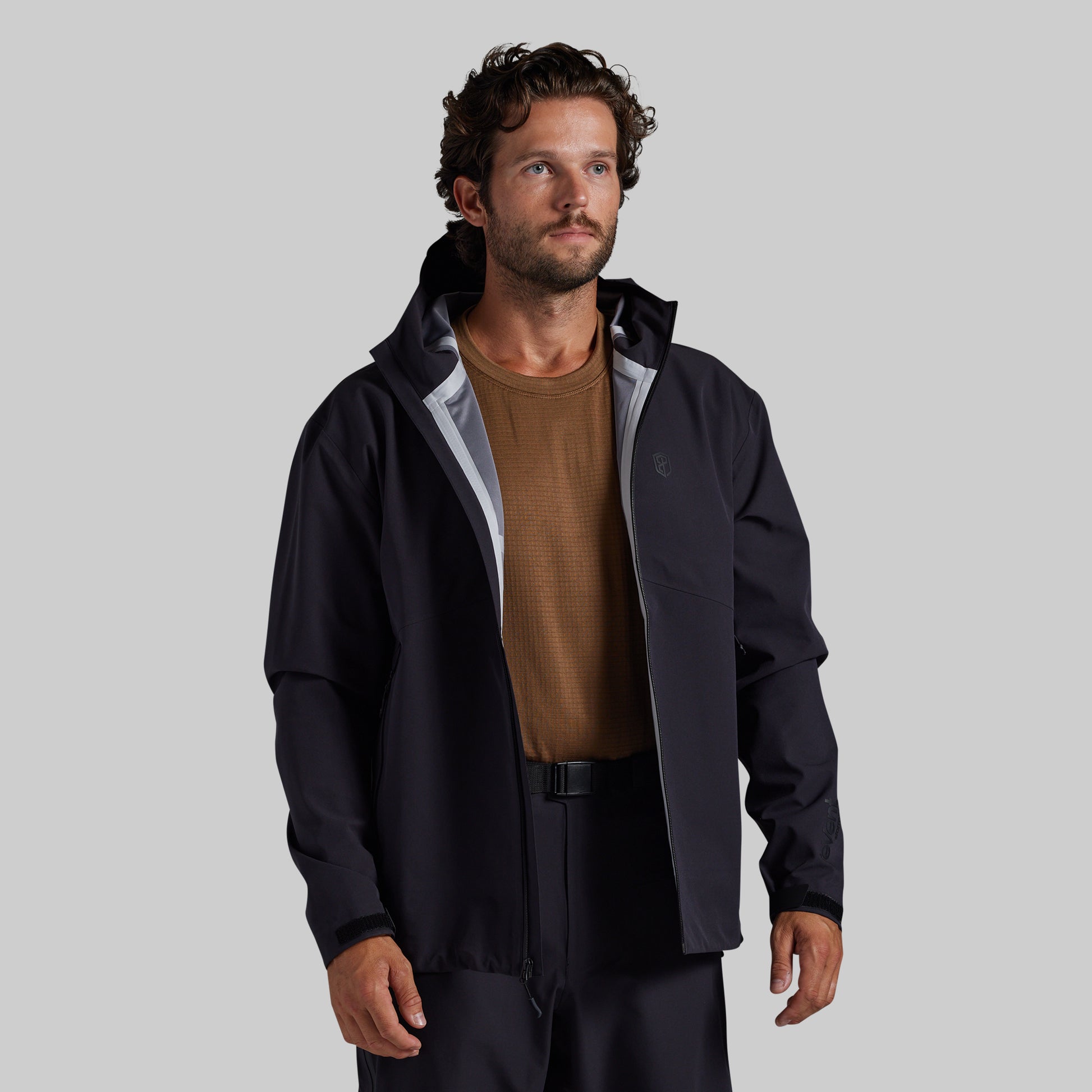 Man wearing the black Mission FLEX Rain Jacket 2.0 open over a base layer