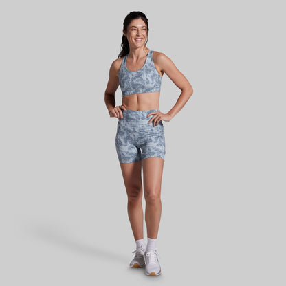 Woman wearing a gray athletic outfit on a light gray background
