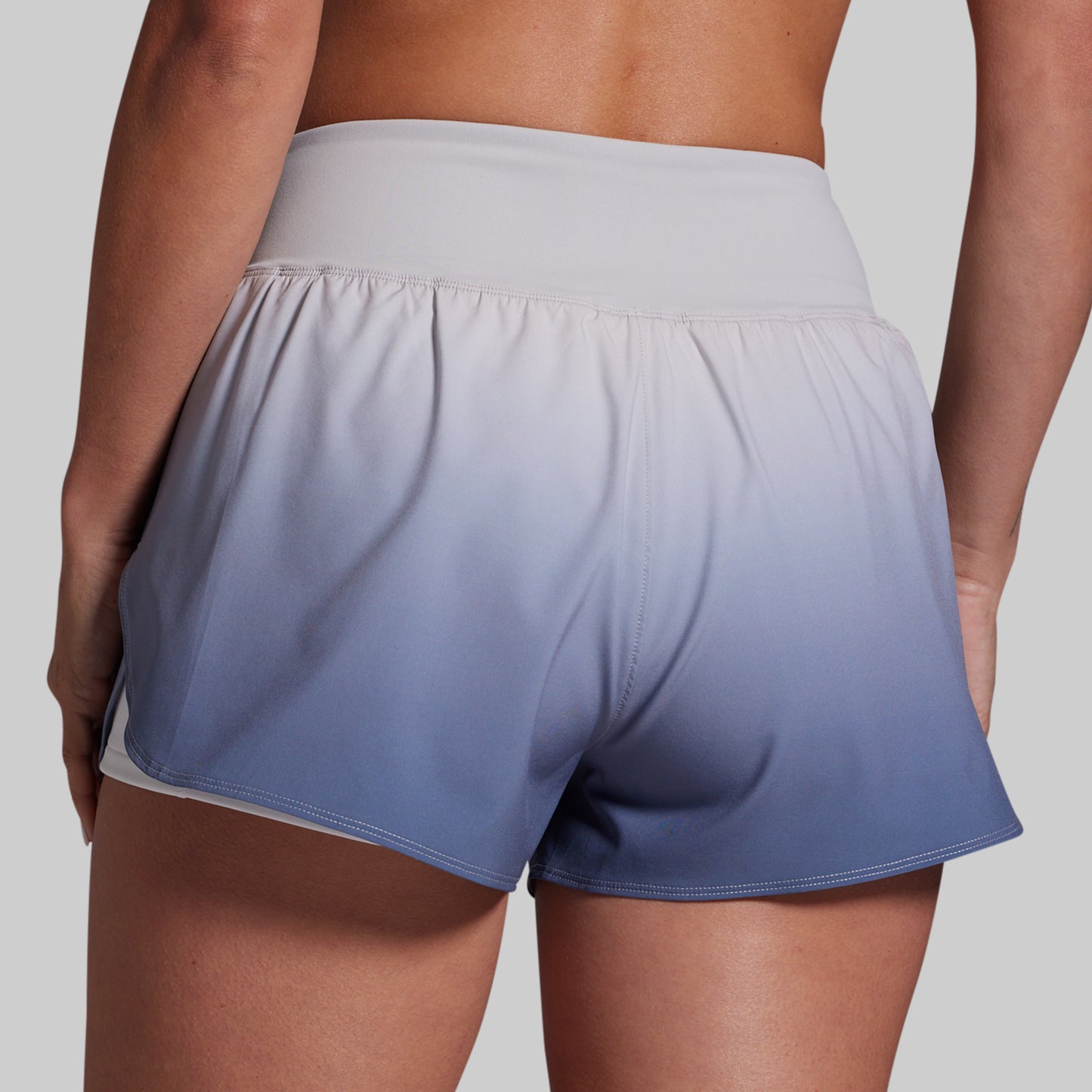 Gradient shorts transitioning from gray to blue on a plain background