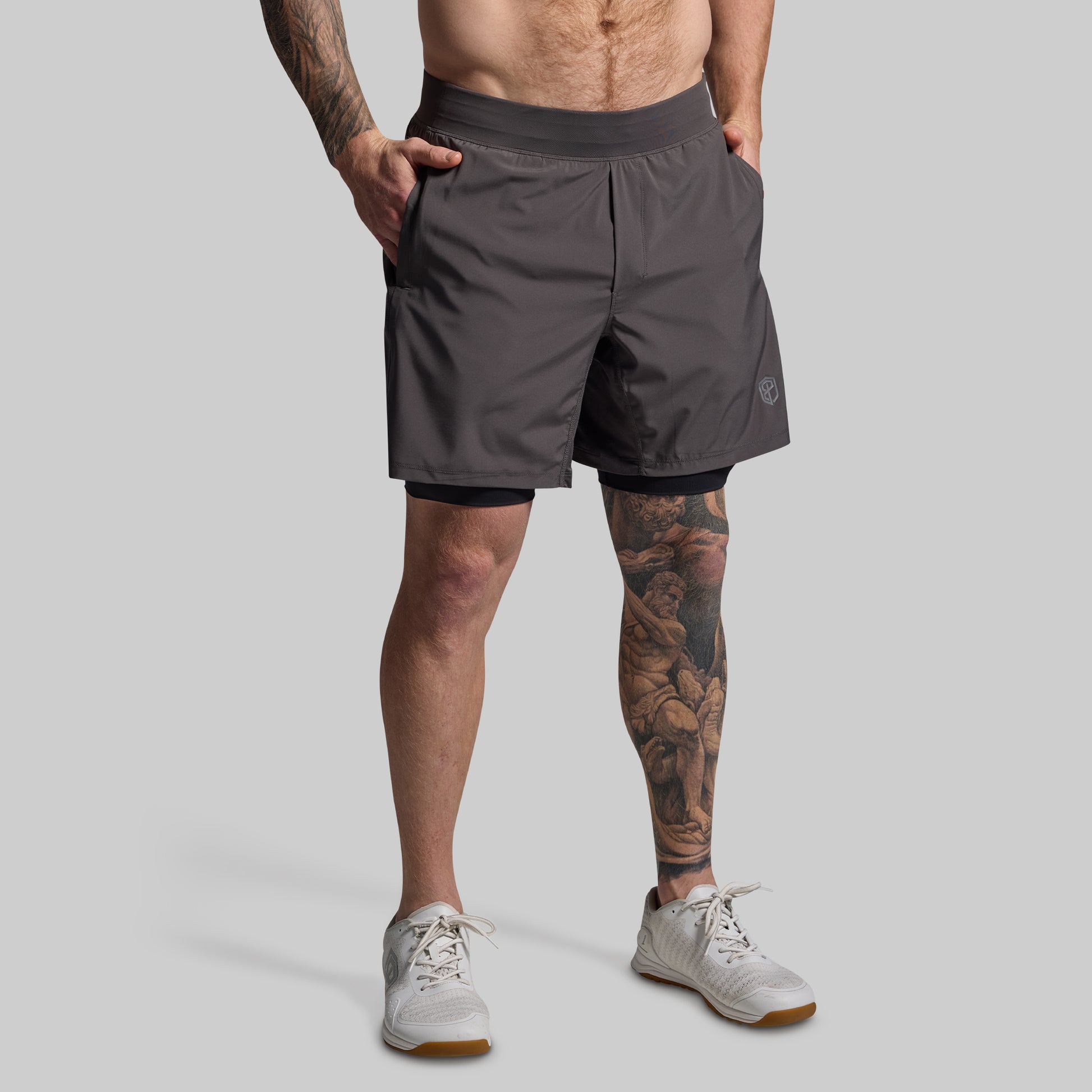 Person wearing gray athletic shorts on a plain background