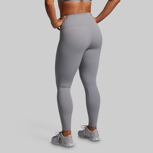 Person wearing gray leggings on a plain background