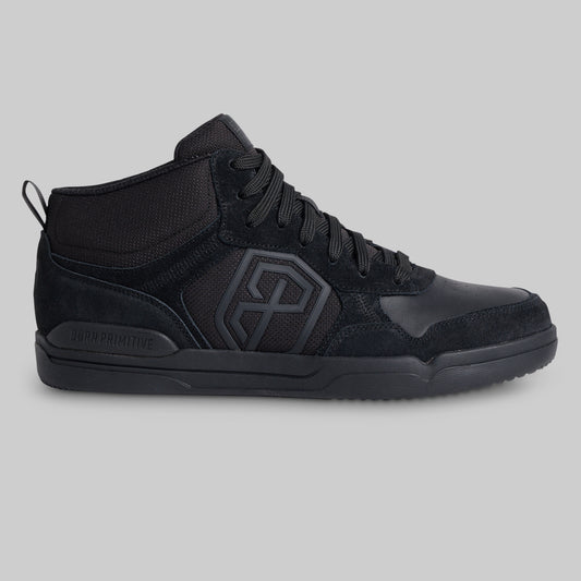 A black mid-top sneaker with a textured mesh and suede upper, featuring a large geometric logo on the side and a pull tab on the heel, shown against a solid gray background.