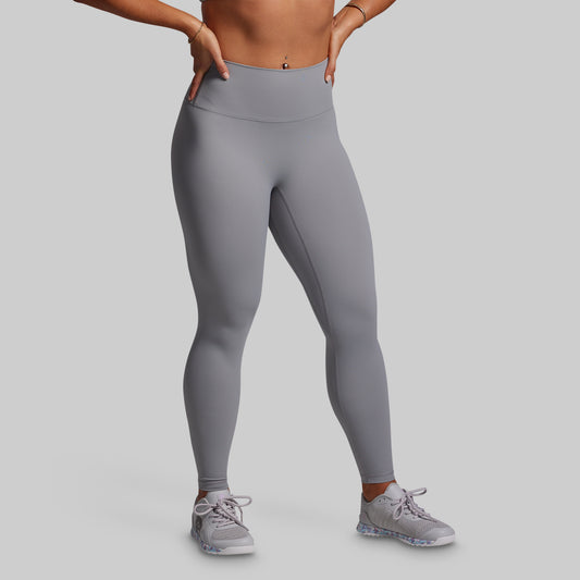 Person wearing gray leggings on a plain background