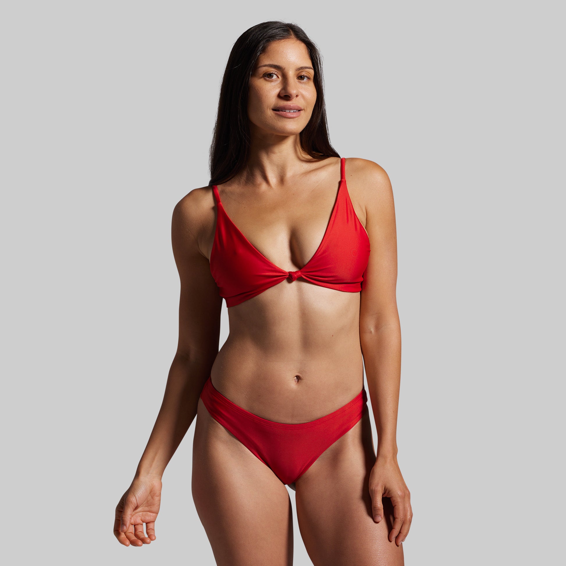 Woman wearing a red bikini against a gray background