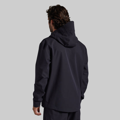 Man wearing the black Mission FLEX Rain Jacket 2.0, back view
