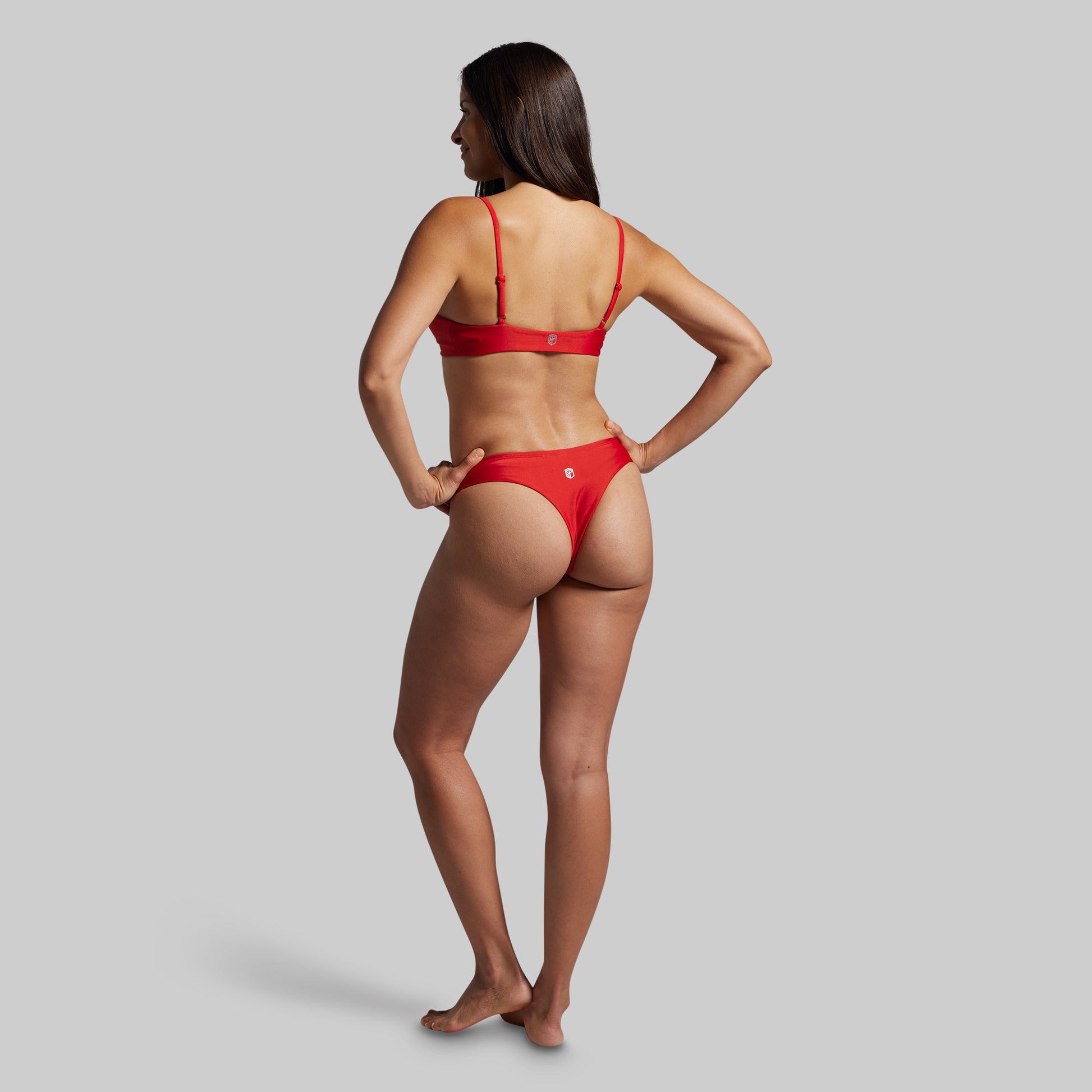 Woman wearing a red bikini on a gray background