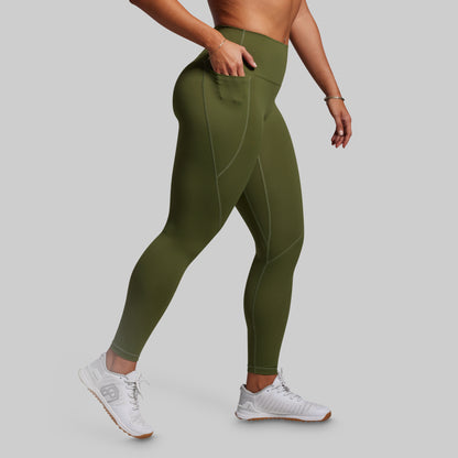 Person wearing olive green leggings on a gray background