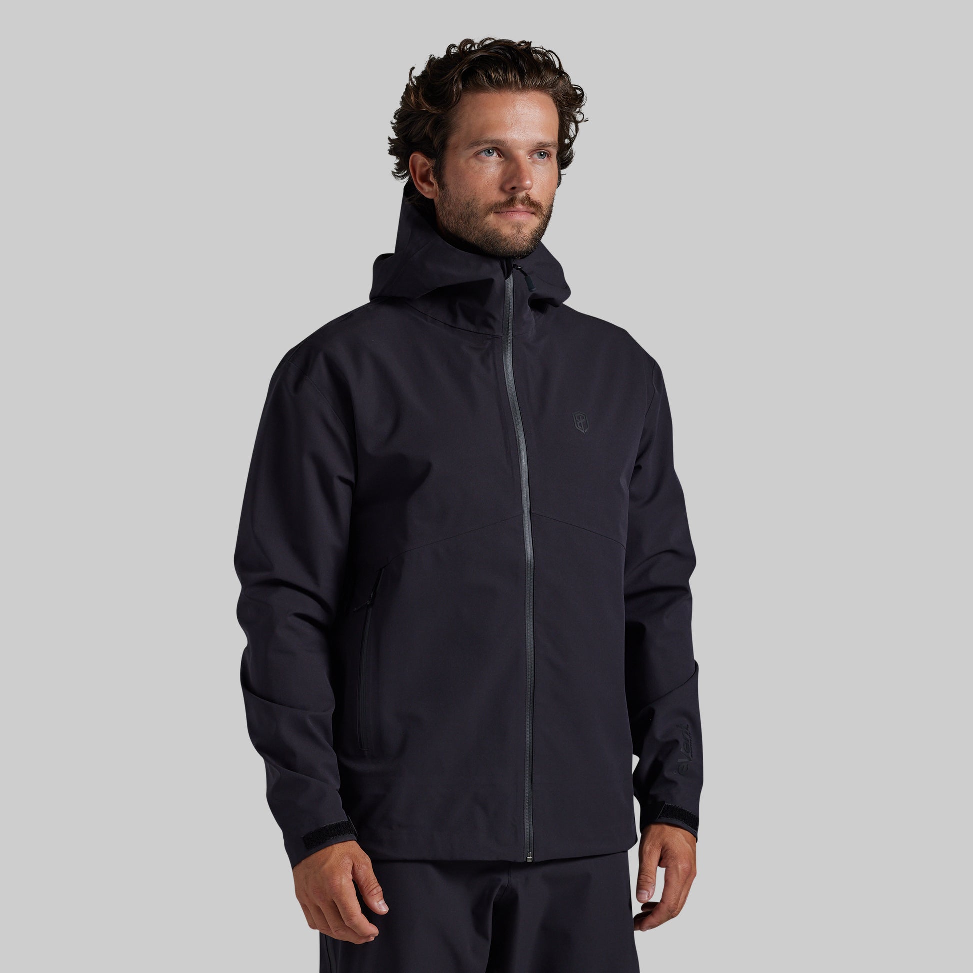 Man wearing the black Mission FLEX Rain Jacket 2.0, front view with hood down