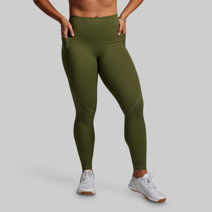 Person wearing green leggings on a gray background
