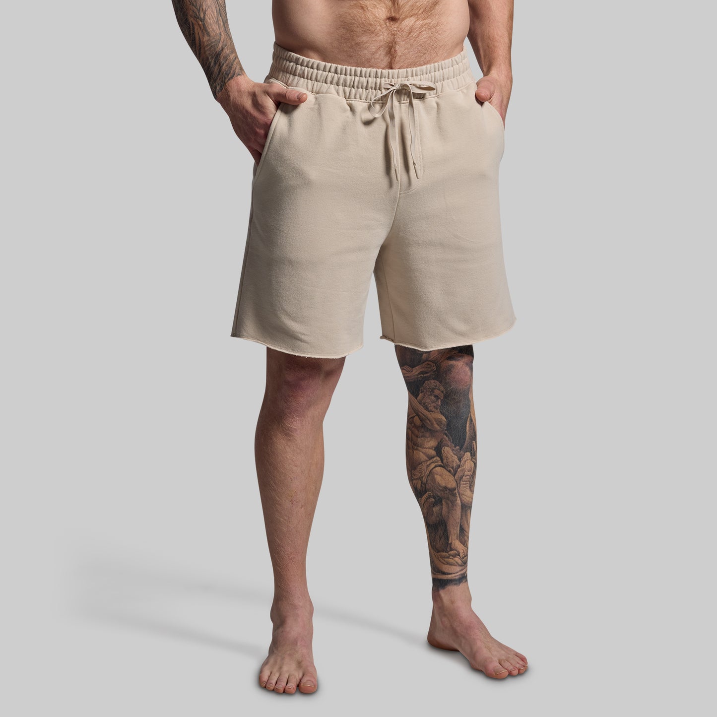 Man wearing beige shorts on a plain background