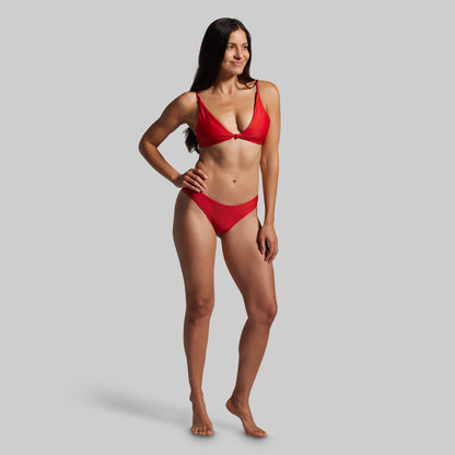 Woman wearing a red bikini against a gray background
