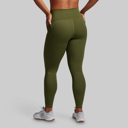 Person wearing olive green leggings on a gray background