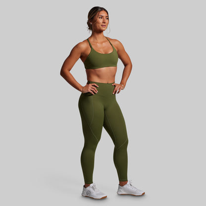 Woman wearing green athletic outfit on a gray background