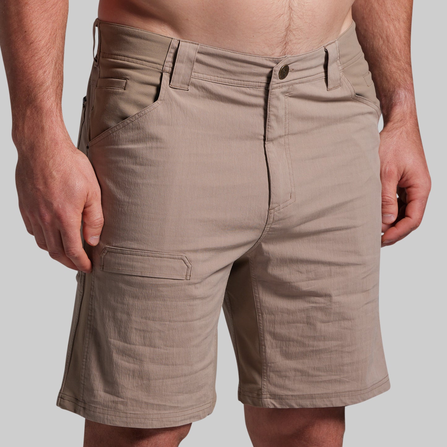 Beige shorts worn by a person on a plain background
