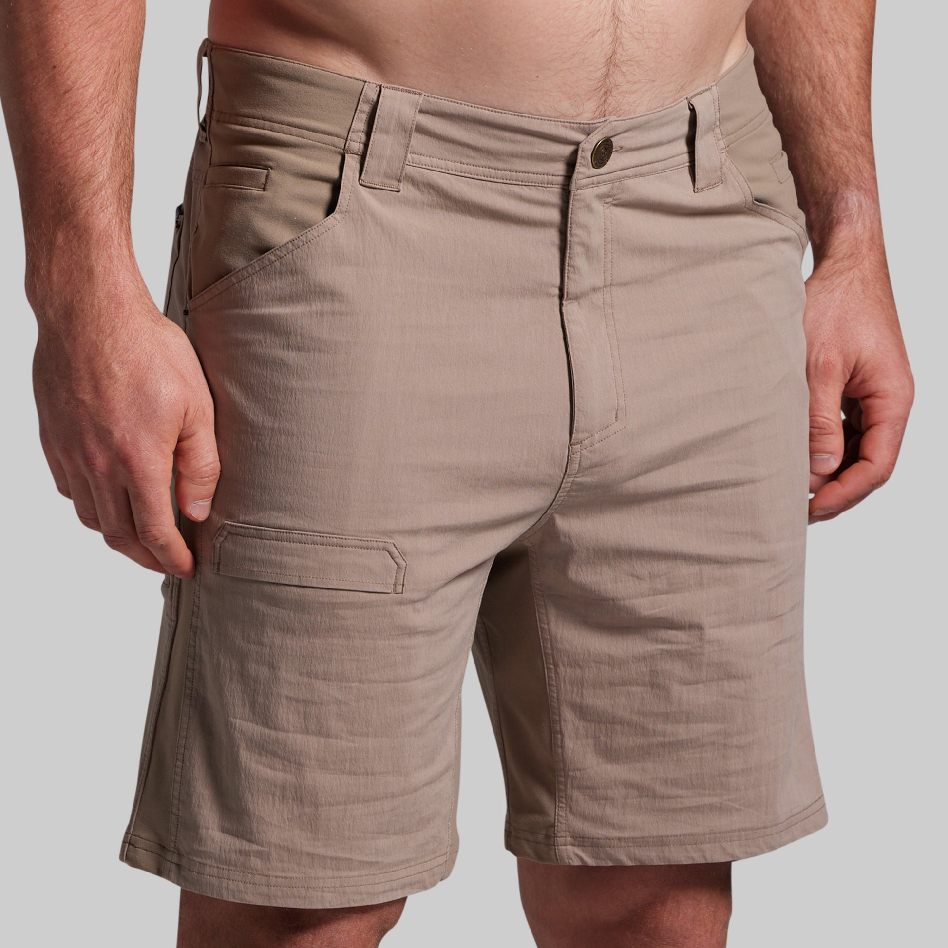 Beige shorts worn by a person on a plain background