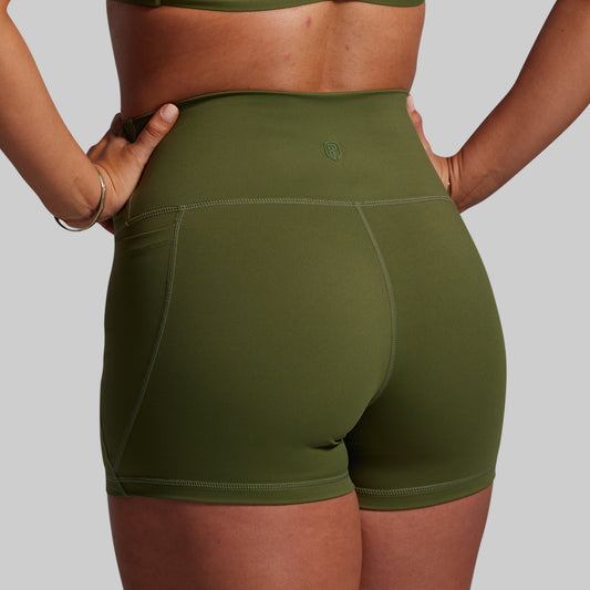Green athletic shorts worn by a person on a gray background