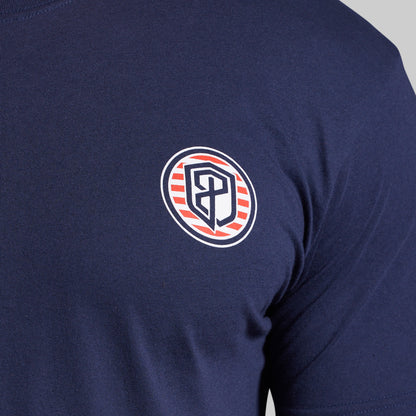 Navy blue t-shirt with a circular logo featuring a shield design on the chest.