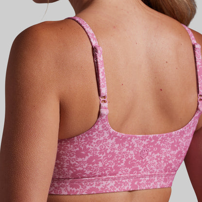 Pink sports bra with floral pattern on a neutral background