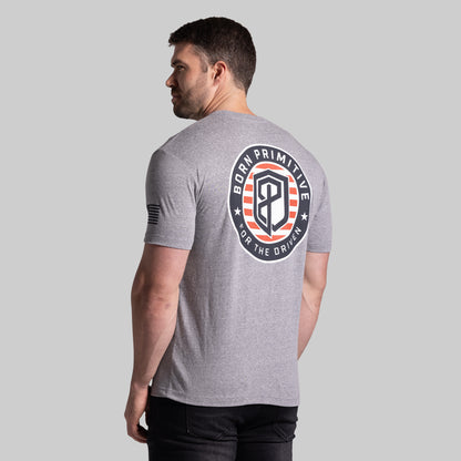 Man wearing a gray t-shirt with a logo on the back against a plain background