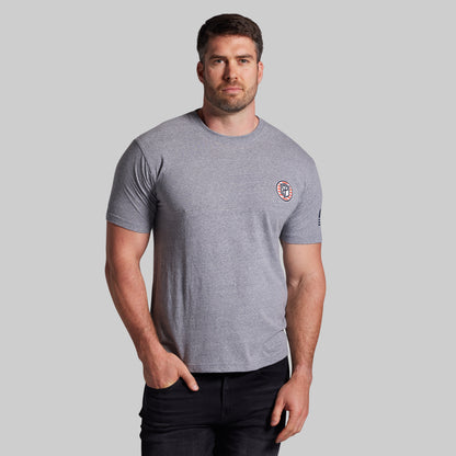 Man wearing a gray t-shirt with a logo on a light gray background