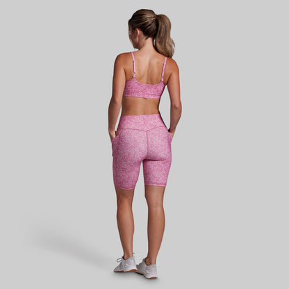 Woman wearing a pink athletic outfit on a gray background