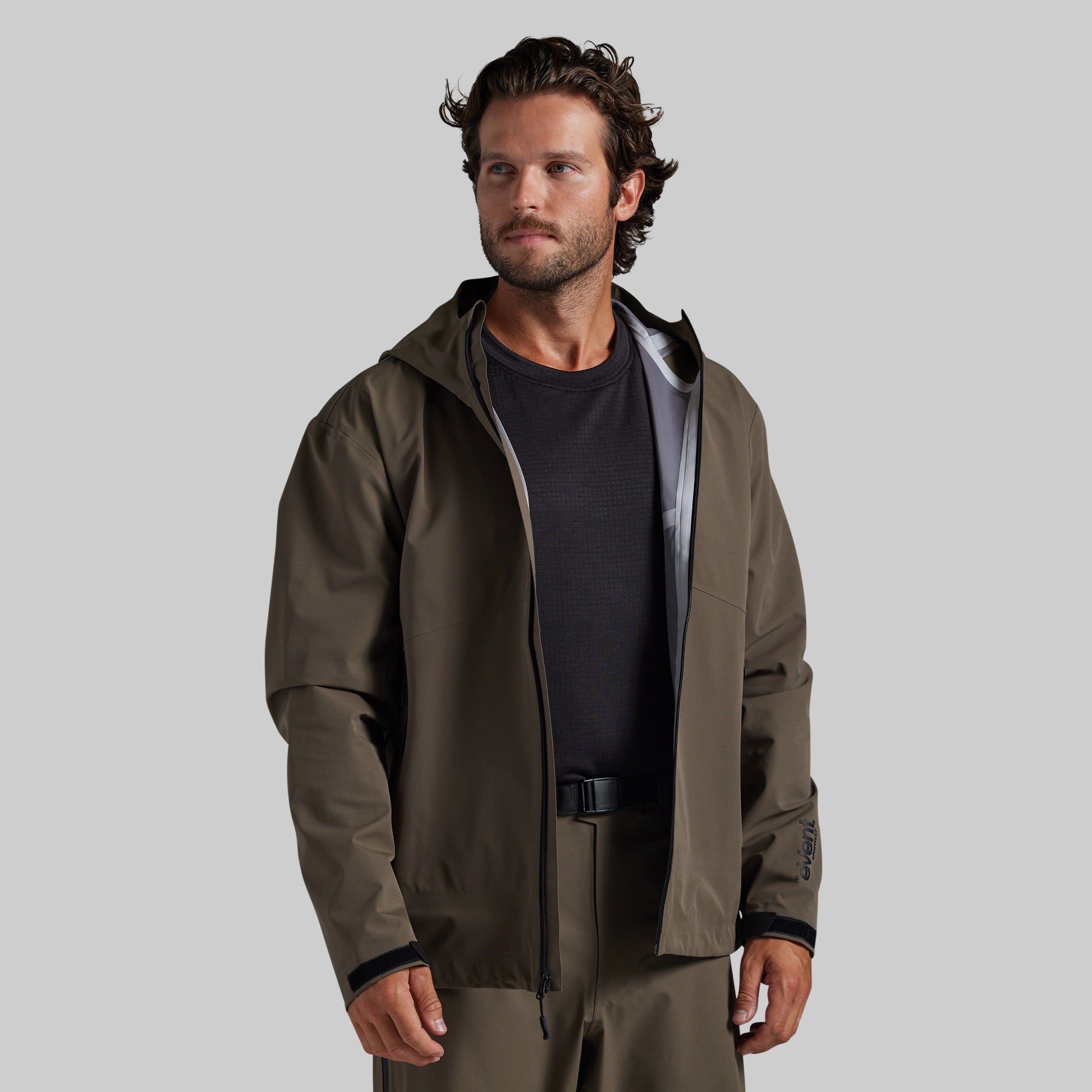 Man wearing the Ranger Green Mission FLEX Rain Jacket 2.0 open over a base layer