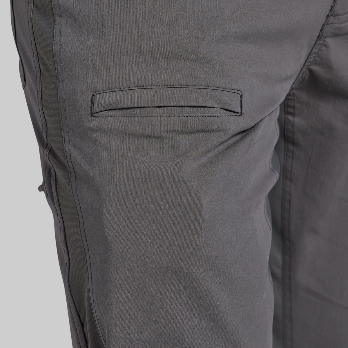 Close-up of dark gray pants showing a side pocket and fabric texture.