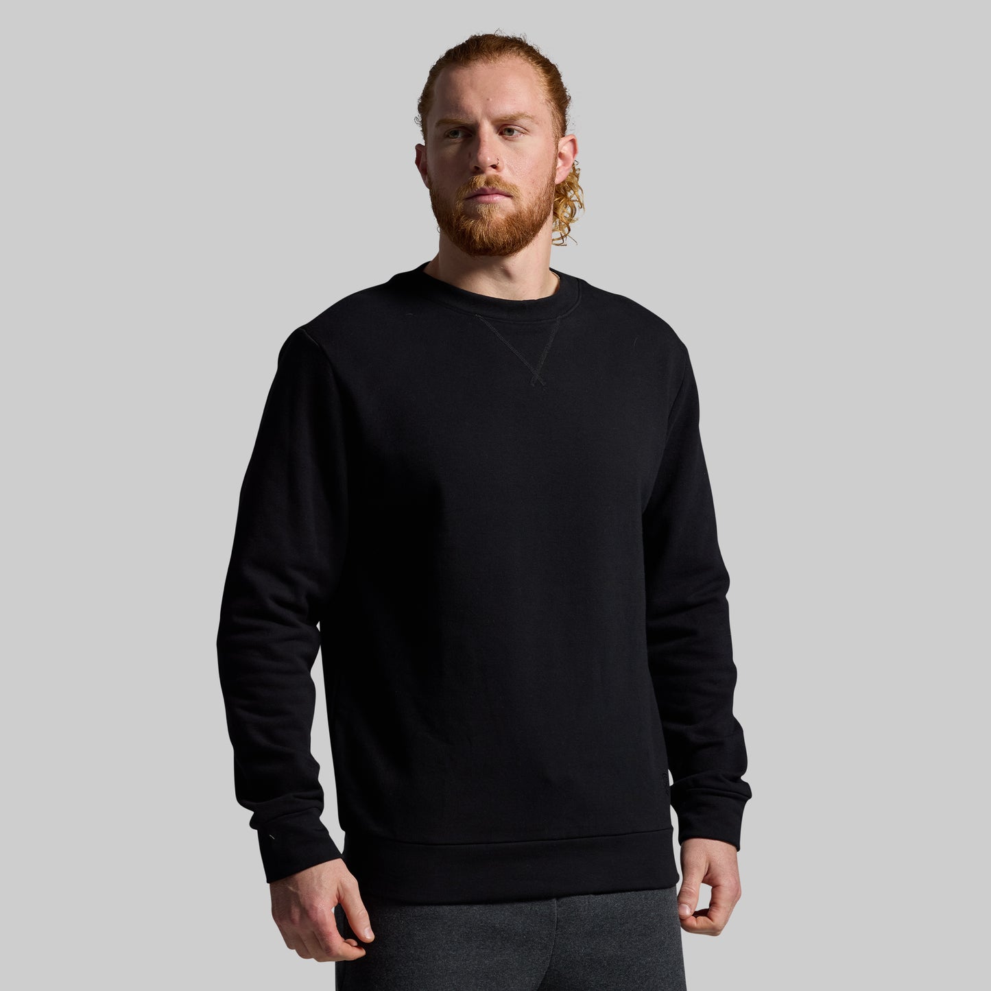 Man wearing a black sweatshirt against a plain background